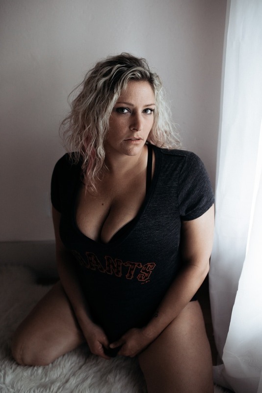 white woman wearing a black tshirt poses for a boudoir shoot with cancer as part of her healing process