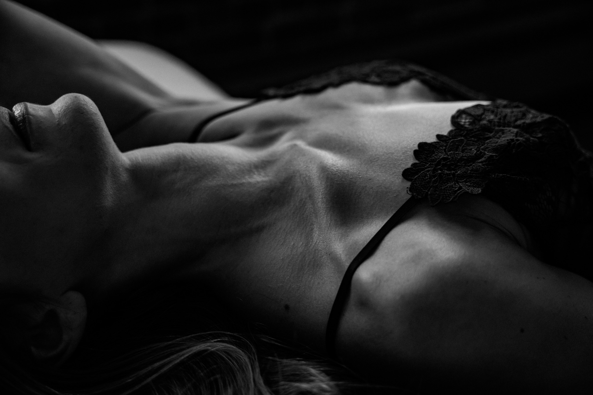 monochrome close up image of a woman's lace bra taken during her boudoir photography session