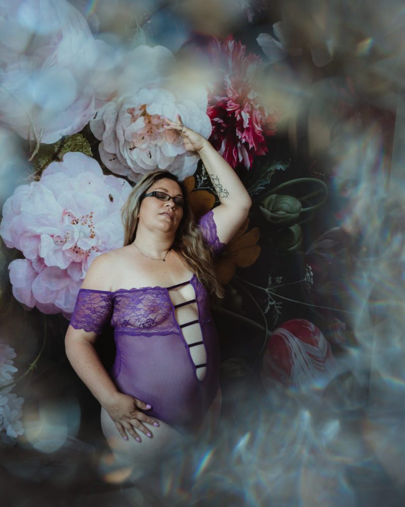 Woman poses in purple lingerie for her boudoir photoshoot at a Sacramento photography studio