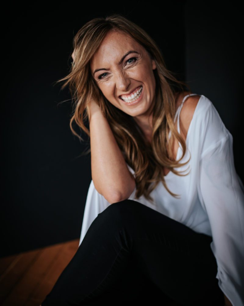 woman flashes a big beautiful smile while her headshot is taken by her Sacramento photographer